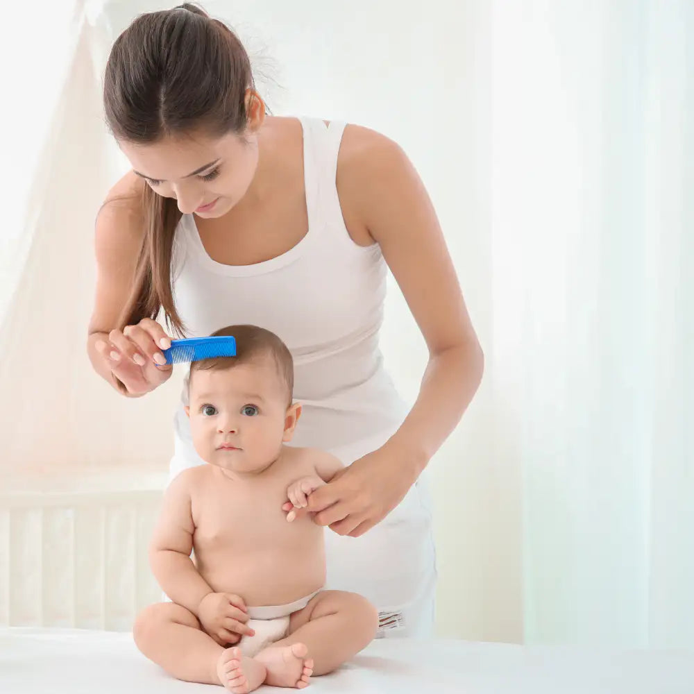 Une maman peignant les cheveux de son bébé assis